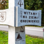 Przybliżenie do napisu "Witamy na ziemi Chojnickiej" witacza Chojnickiego.