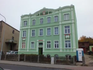 Kamienica przy ul. Mickiewicz 44 z odnowioną elewacją w kolorze zielonym.