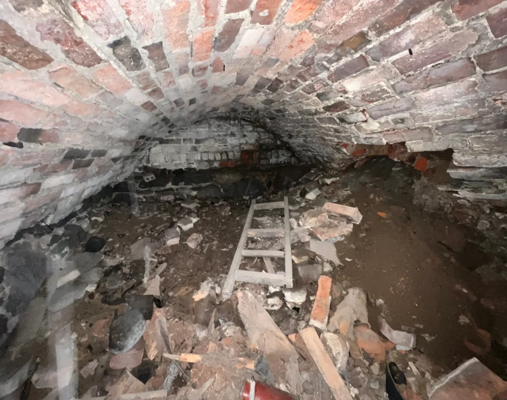 Piwnica. Widok na ścianę południową. Z prawej strony widoczne miejsce awarii sklepienia.