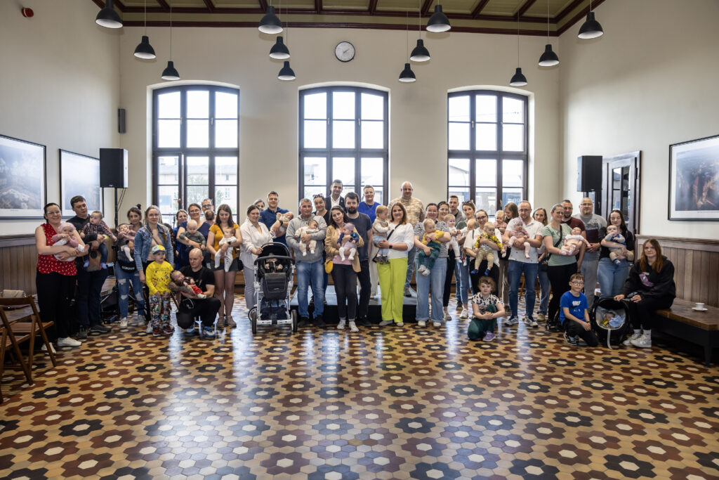Wspólne pamiątkowe zdjęcie z najmłodszymi mieszkańcami i rodzicami